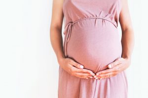 Pregnant,Woman,In,Dress,Holds,Hands,On,Belly,On,A